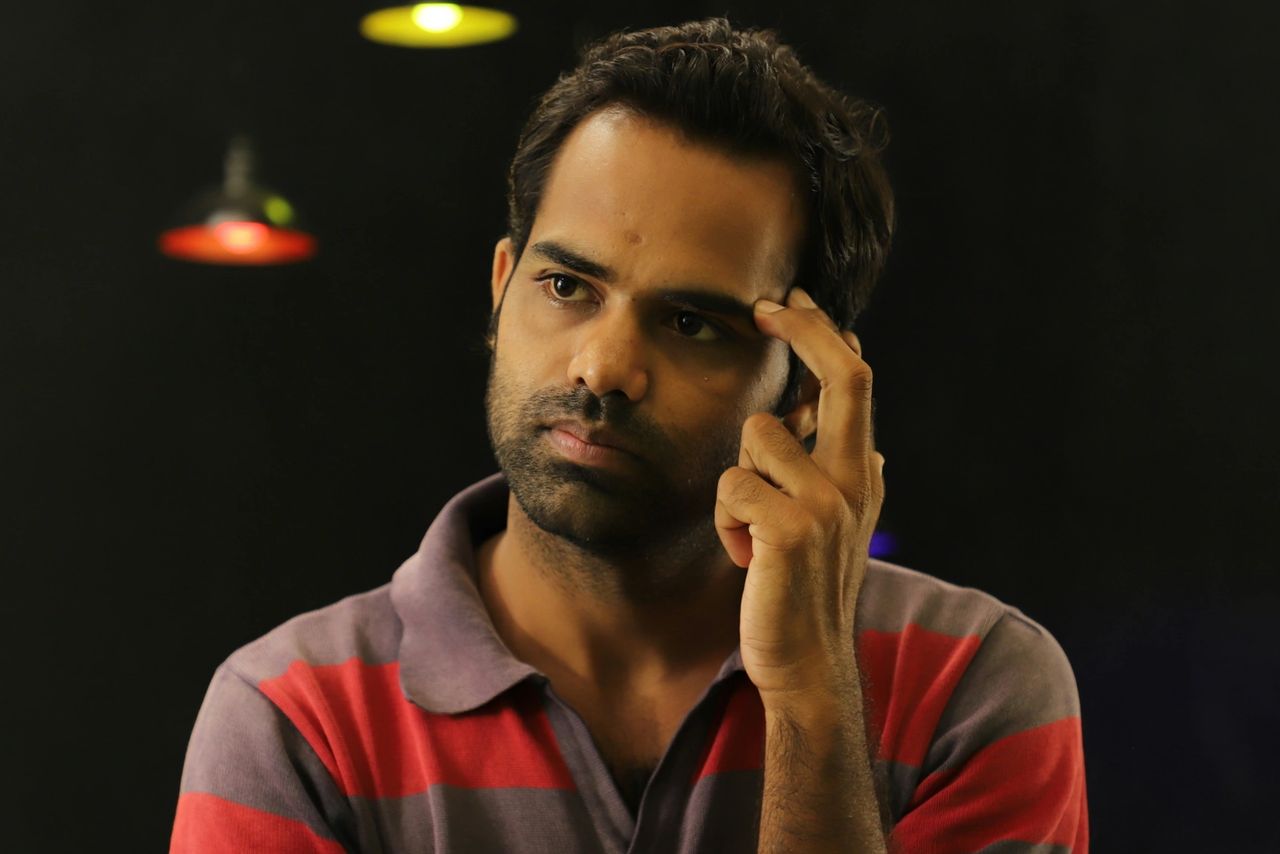 Man in red and grey striped shirt thinking