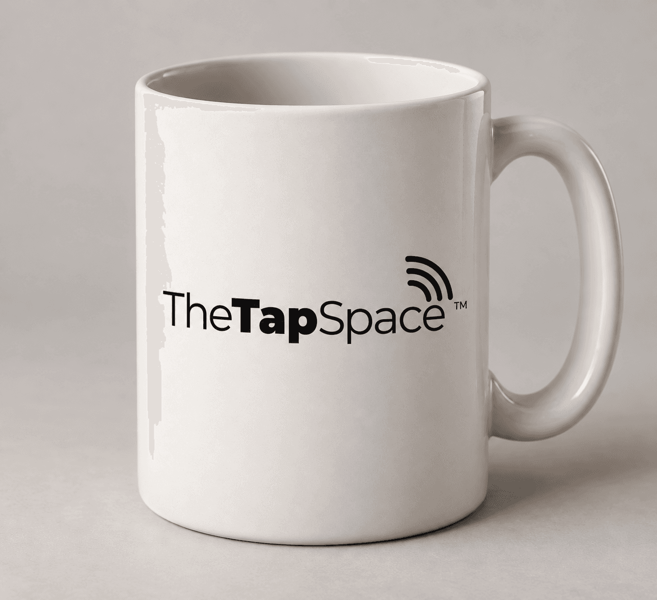 White coffee mug bearing the black TheTapSpace logo