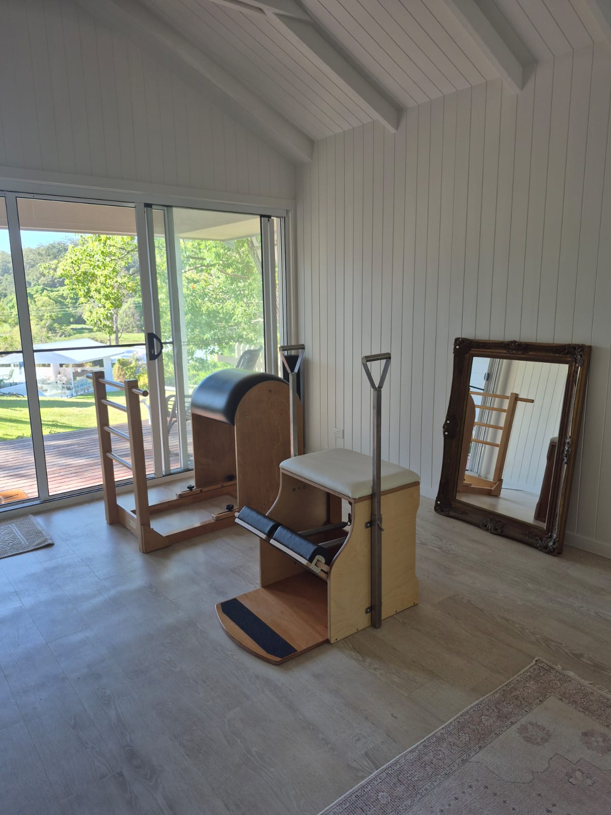 Close-up of Pilates reformer and props in a calm, minimalist studio space.