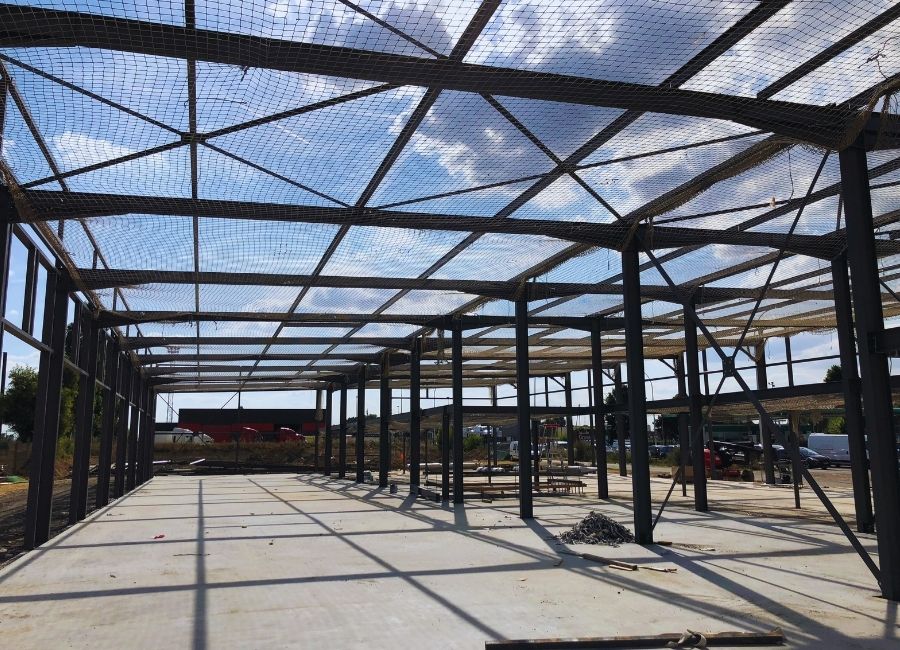 Charpente métallique en cours de montage sur dalle béton, vue de l’ossature complète.