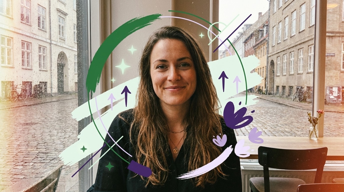 En smilende kvinde med langt hår kigger ud af en regnvåd rude mod brostensgade med bygninger. Grafiske elementer.