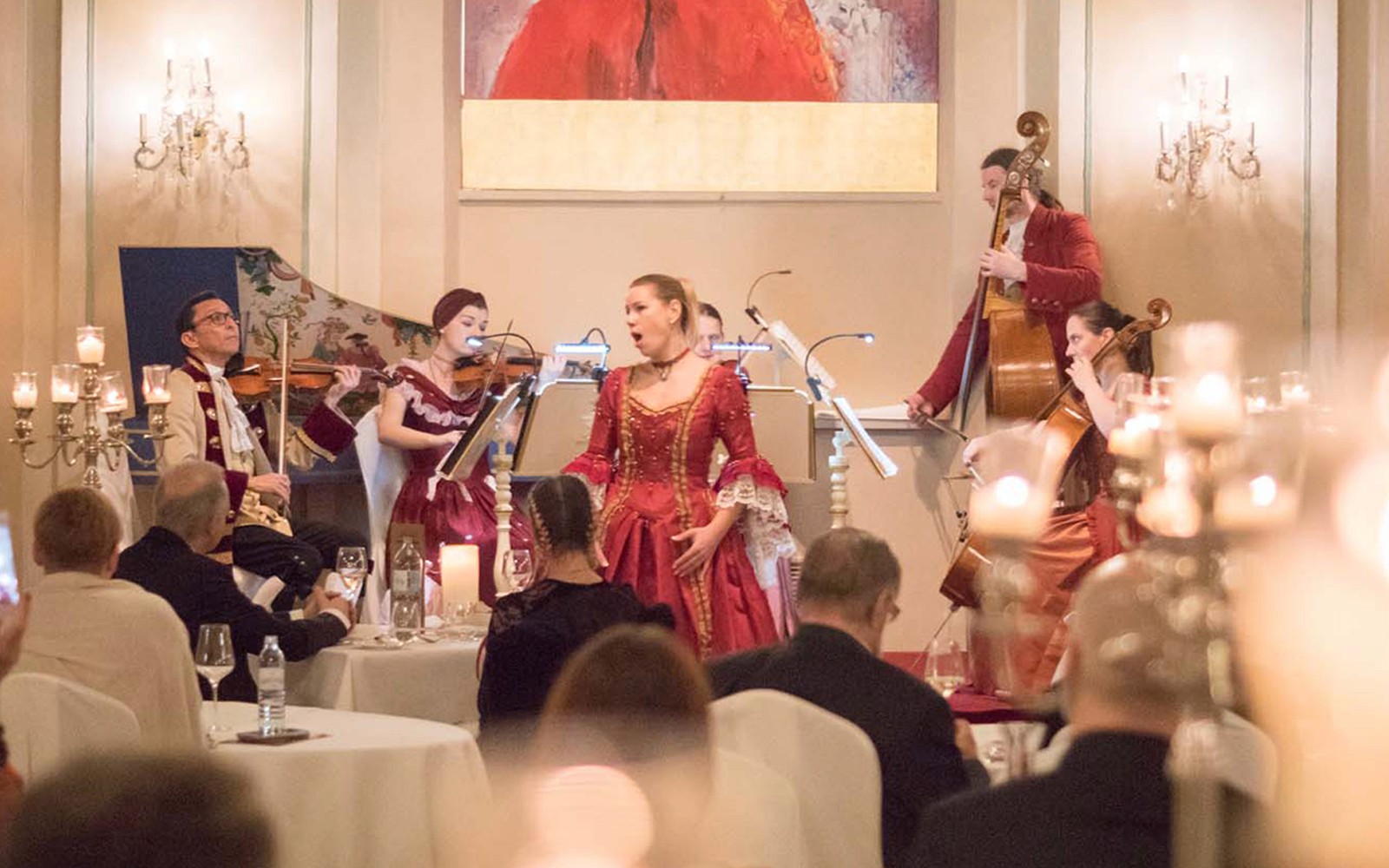 Musikere i historiske kostumer optræder ved en Mozart-koncert på et historisk spillested i Salzburg.