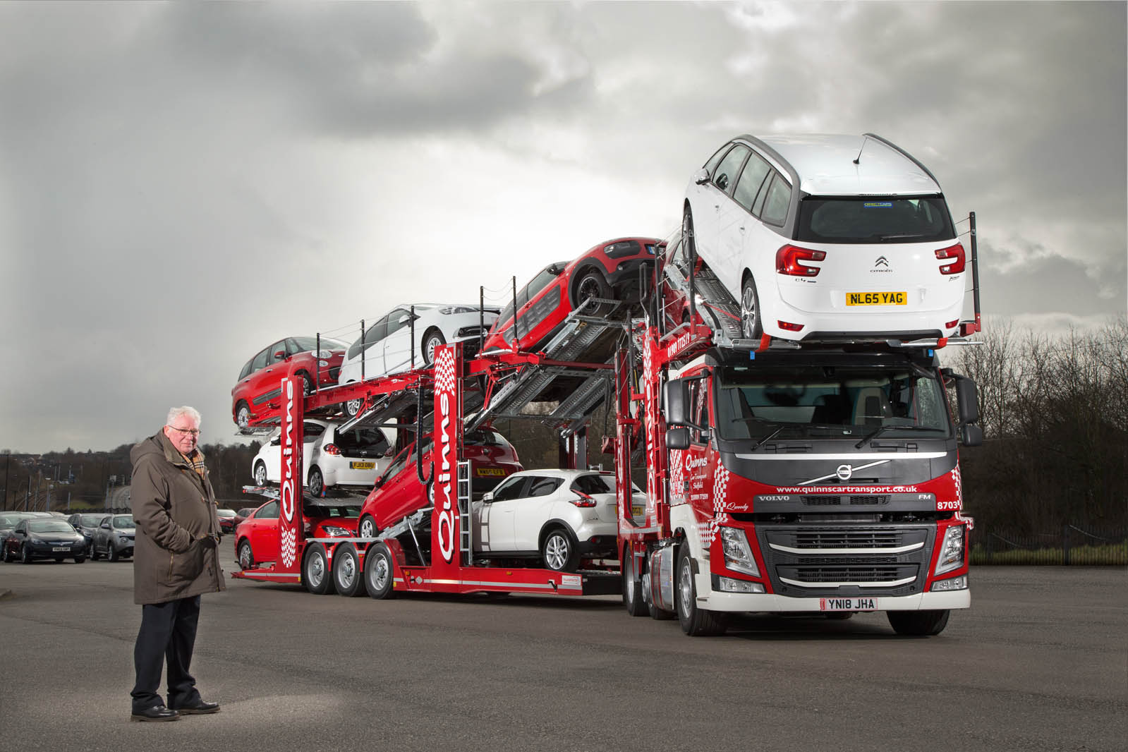 A European car transporter on a highway featuring advanced safety equipment, reflecting compliance with German safety standards.