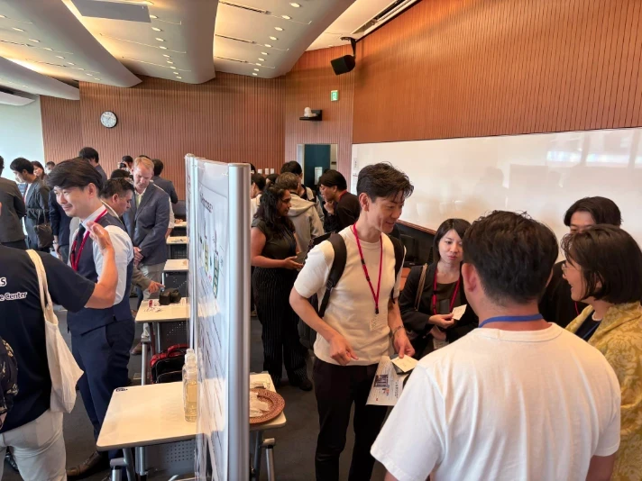 Startup showcase area with attendees gathered around booths having discussions and exchanging ideas.