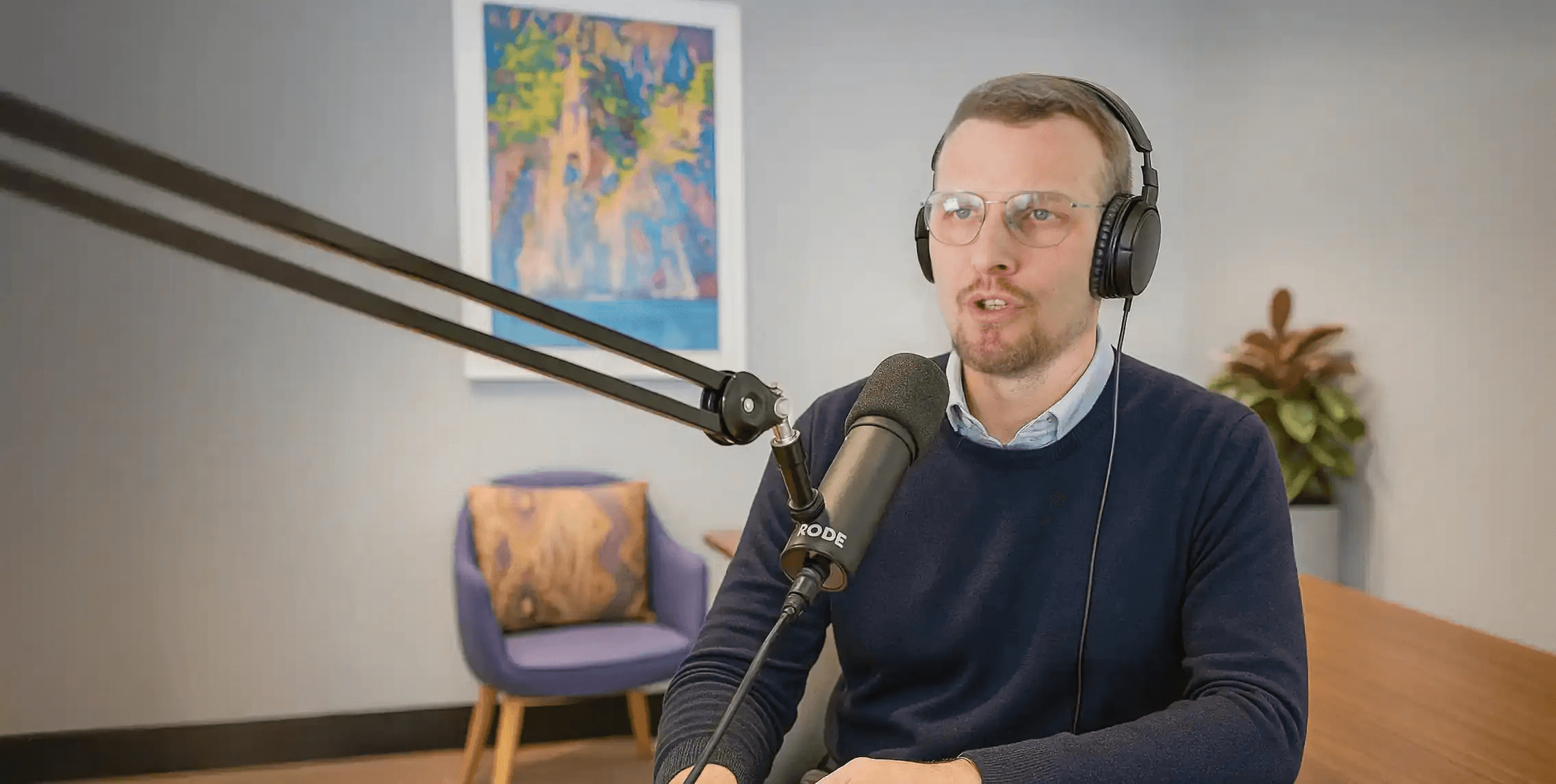 Mann spricht in Podcast-Studio in Mikrofon während einer Aufnahme