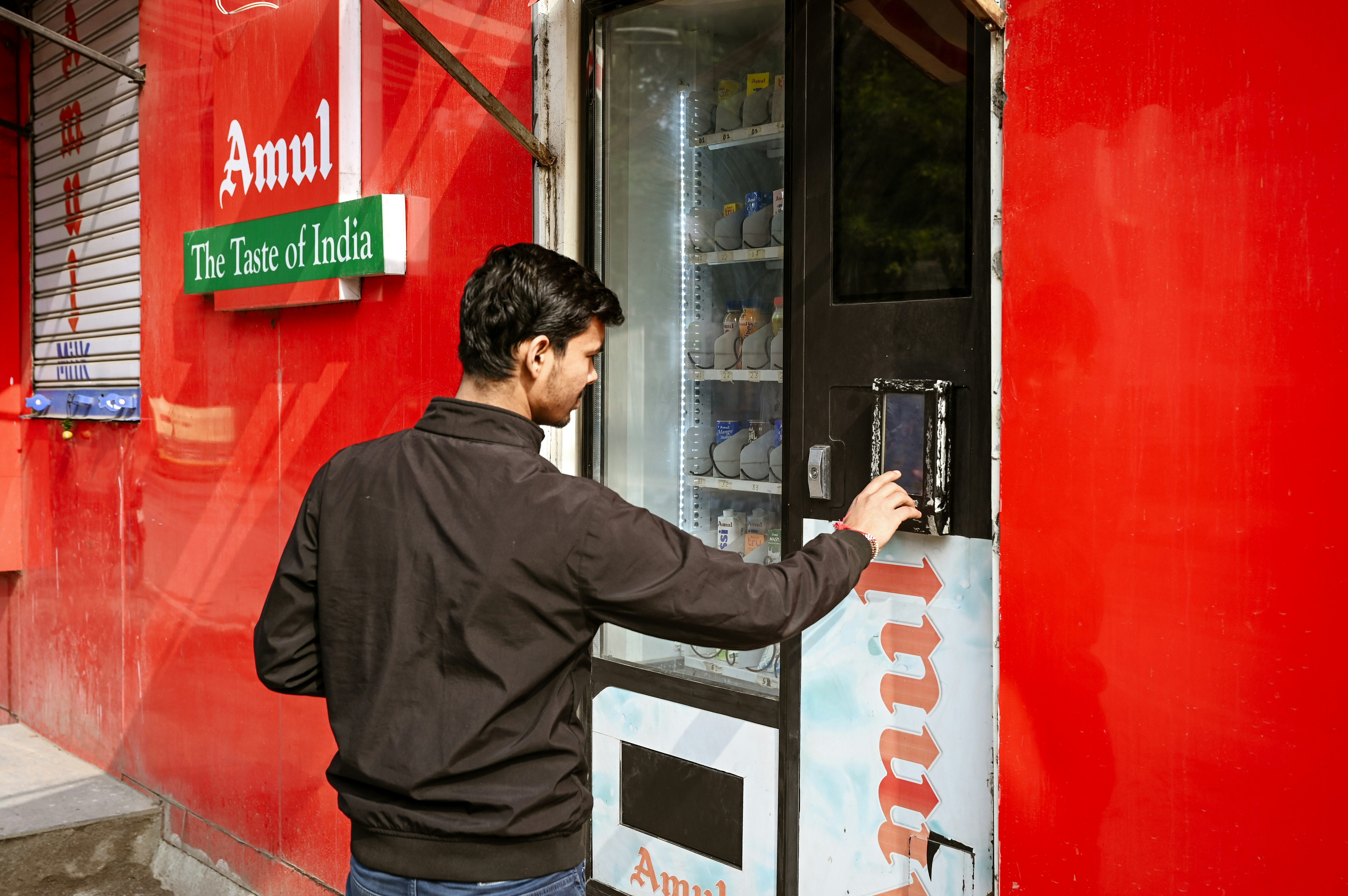 A man is using an amul product vending machine.