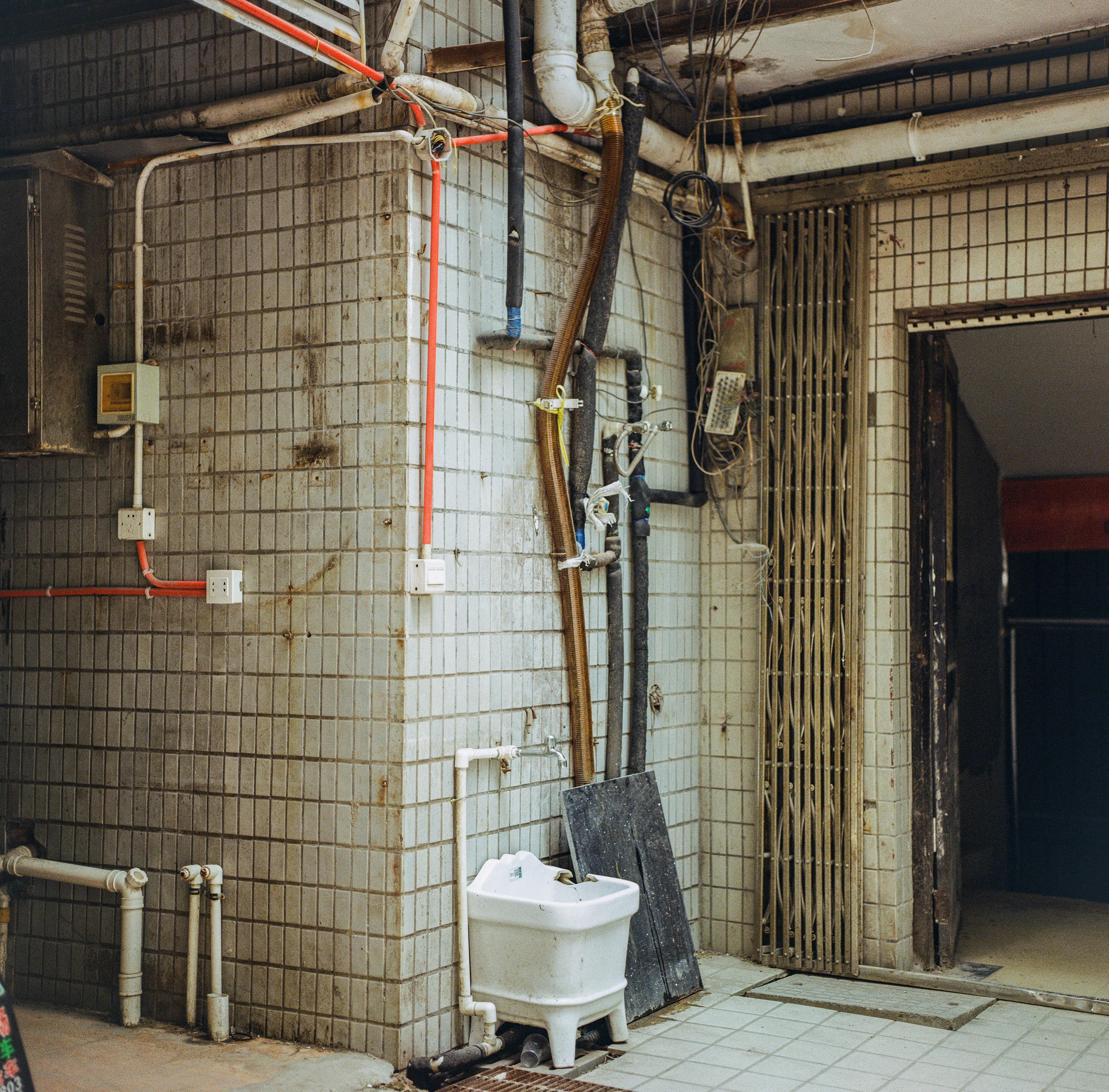white plastic container beside brown wooden wall
