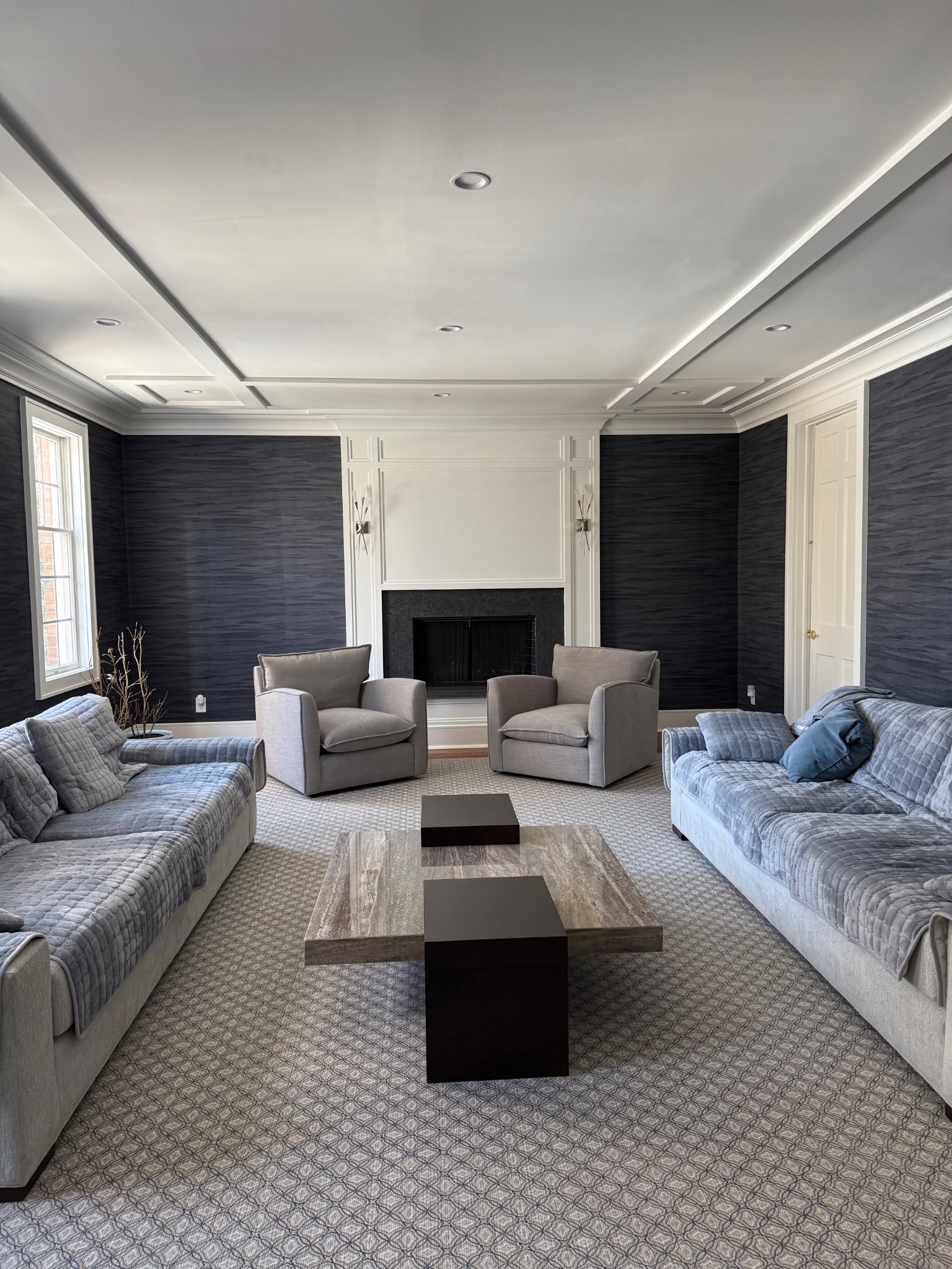 Living room renovation with paneled accent walls, fireplace, and modern seating layout