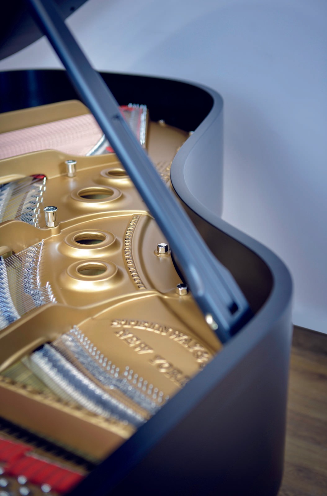 A macro shot of the elegant satin ebony lid, showing the fine texture and restoration quality of this Steinway & Sons grand piano.