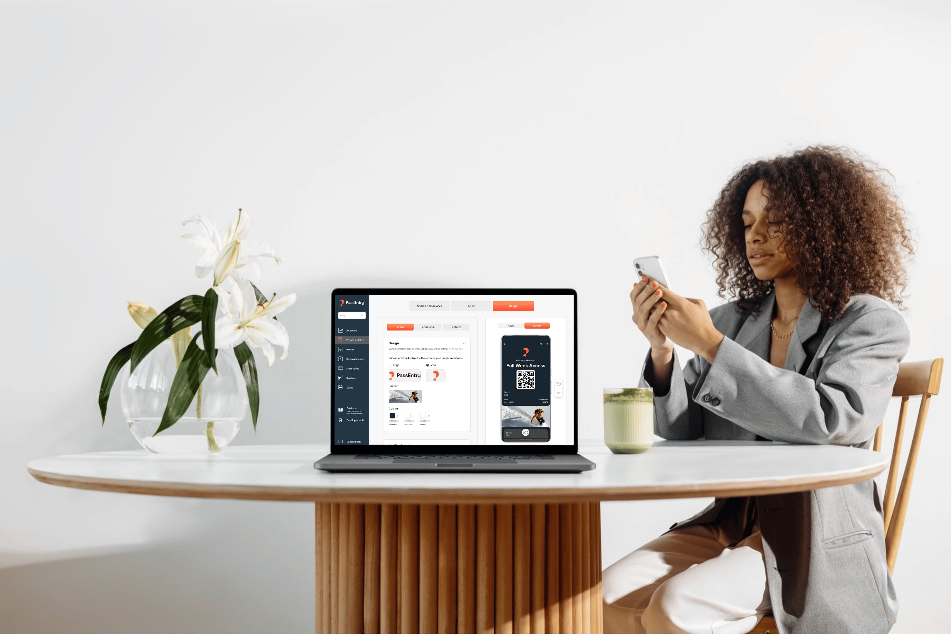 Person using the PassEntry dashboard on a laptop to design and preview a digital wallet pass.