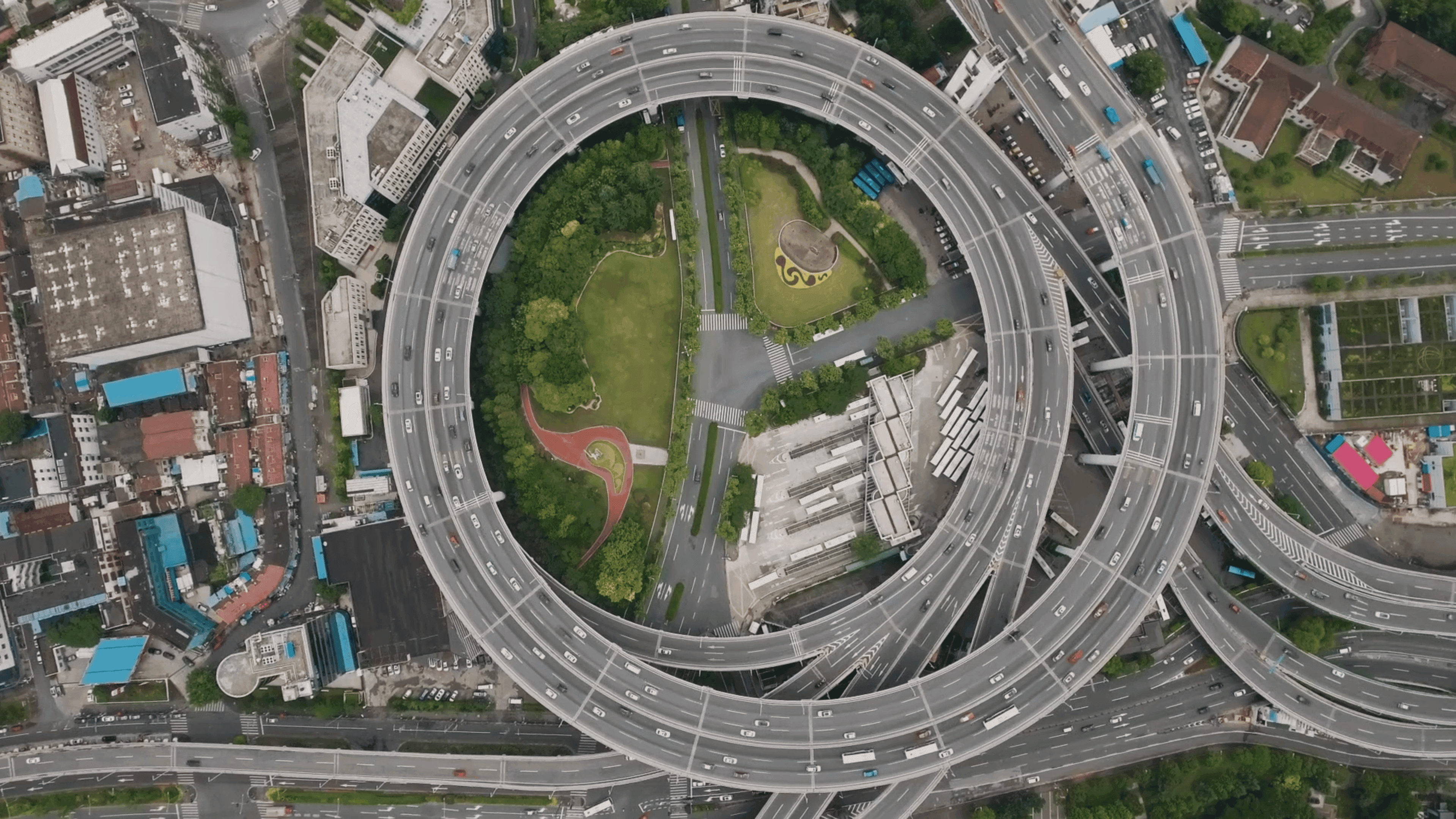 An aerial view of a circular highway intersection in an urban area