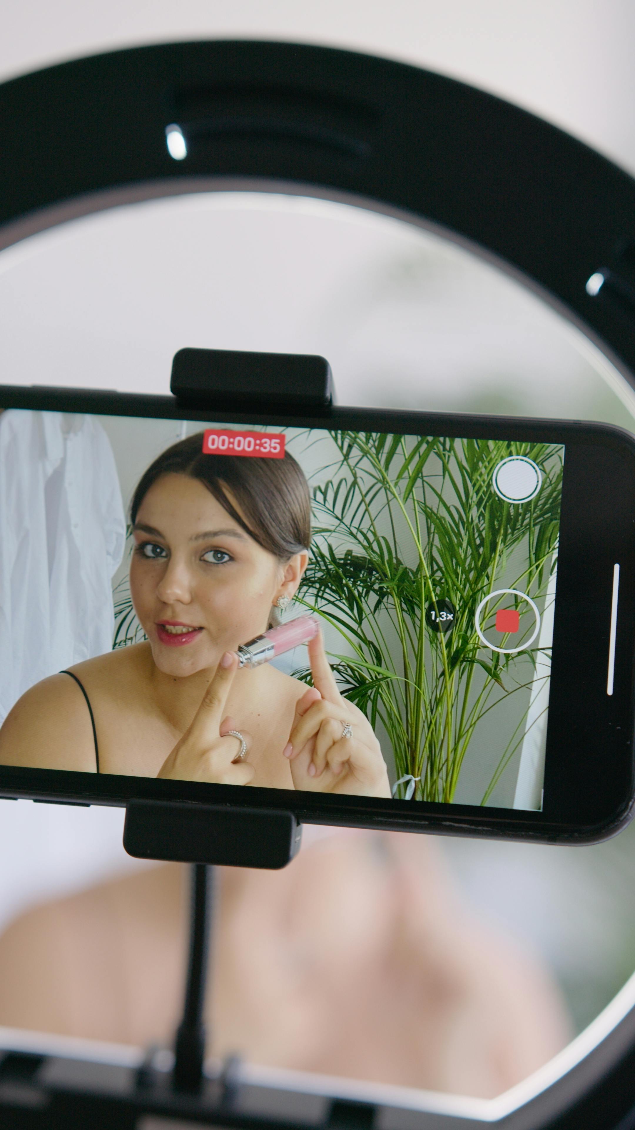 a-young-woman-records-a-makeup-tutorial-on-her-smartphone-at-home,-showcasing-a- - hanna-pad (pexels)