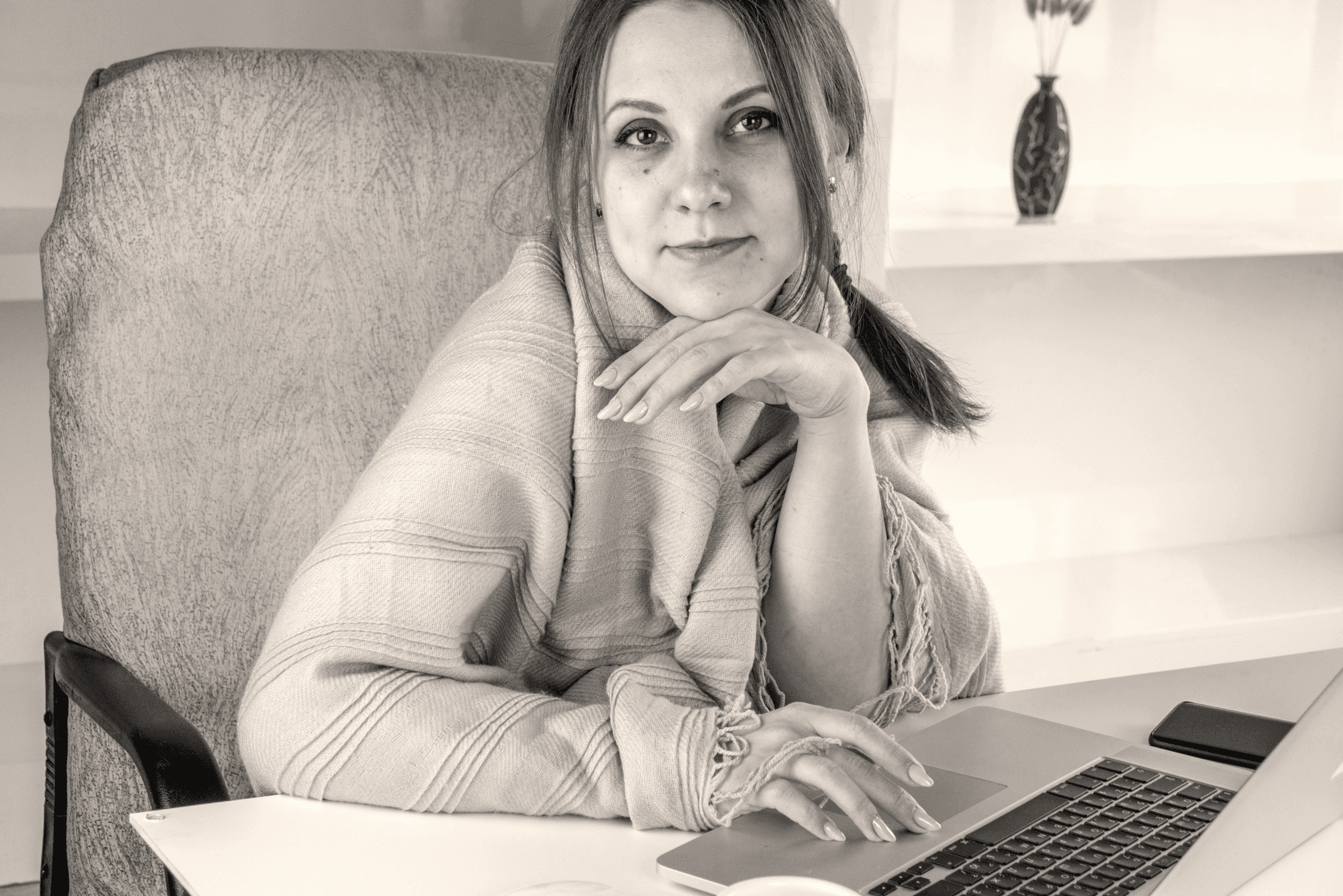 a woman sitting in front of a laptop computer