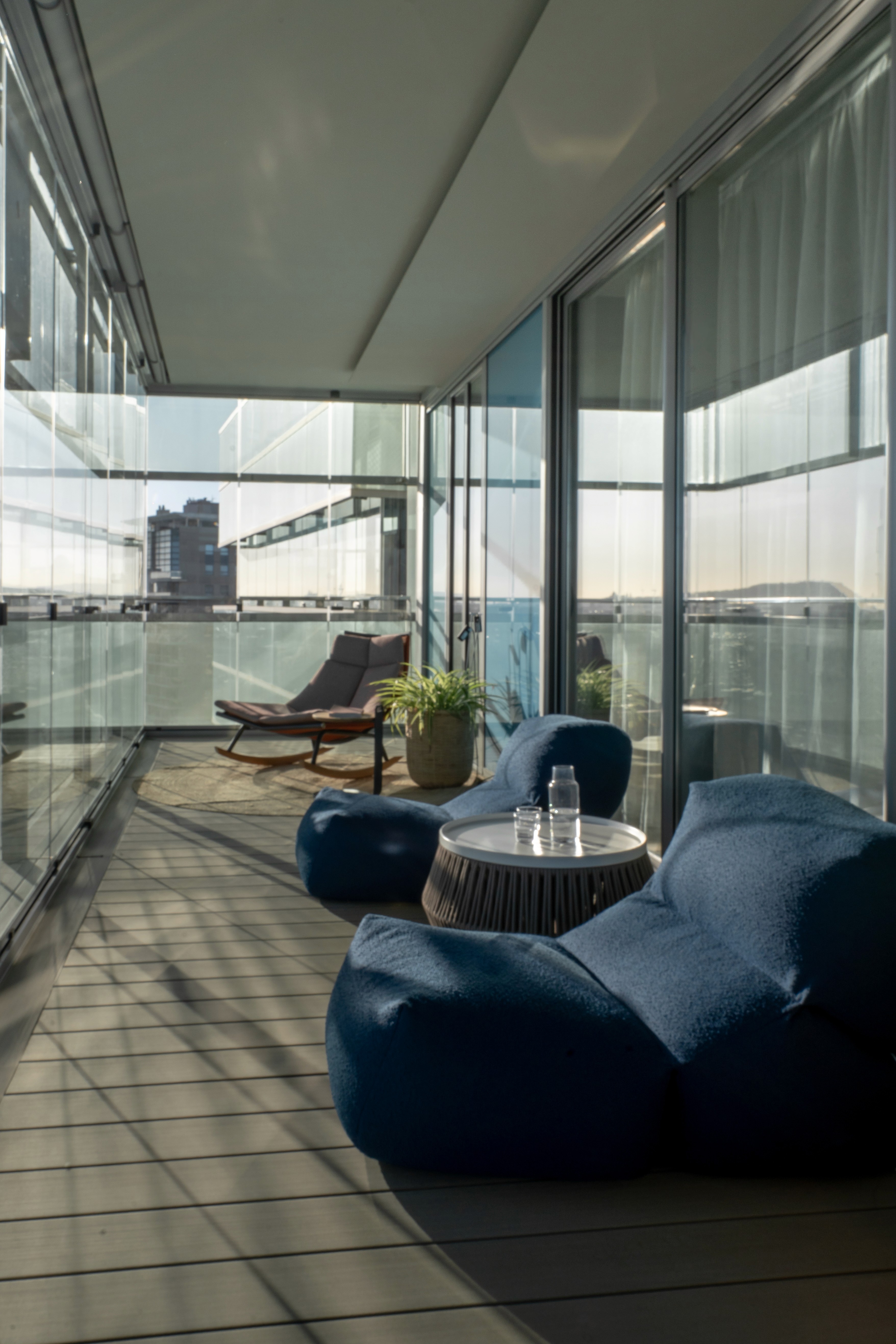 Zona sofás en terraza acristalada con vistas al mar