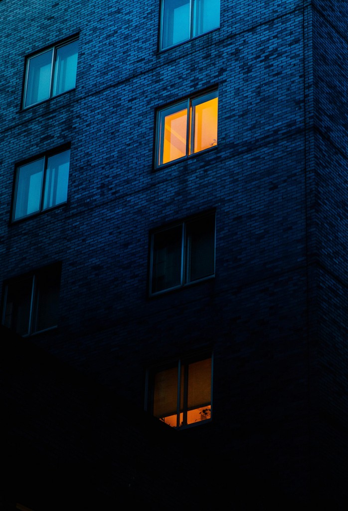 A tall building with windows lit up at night