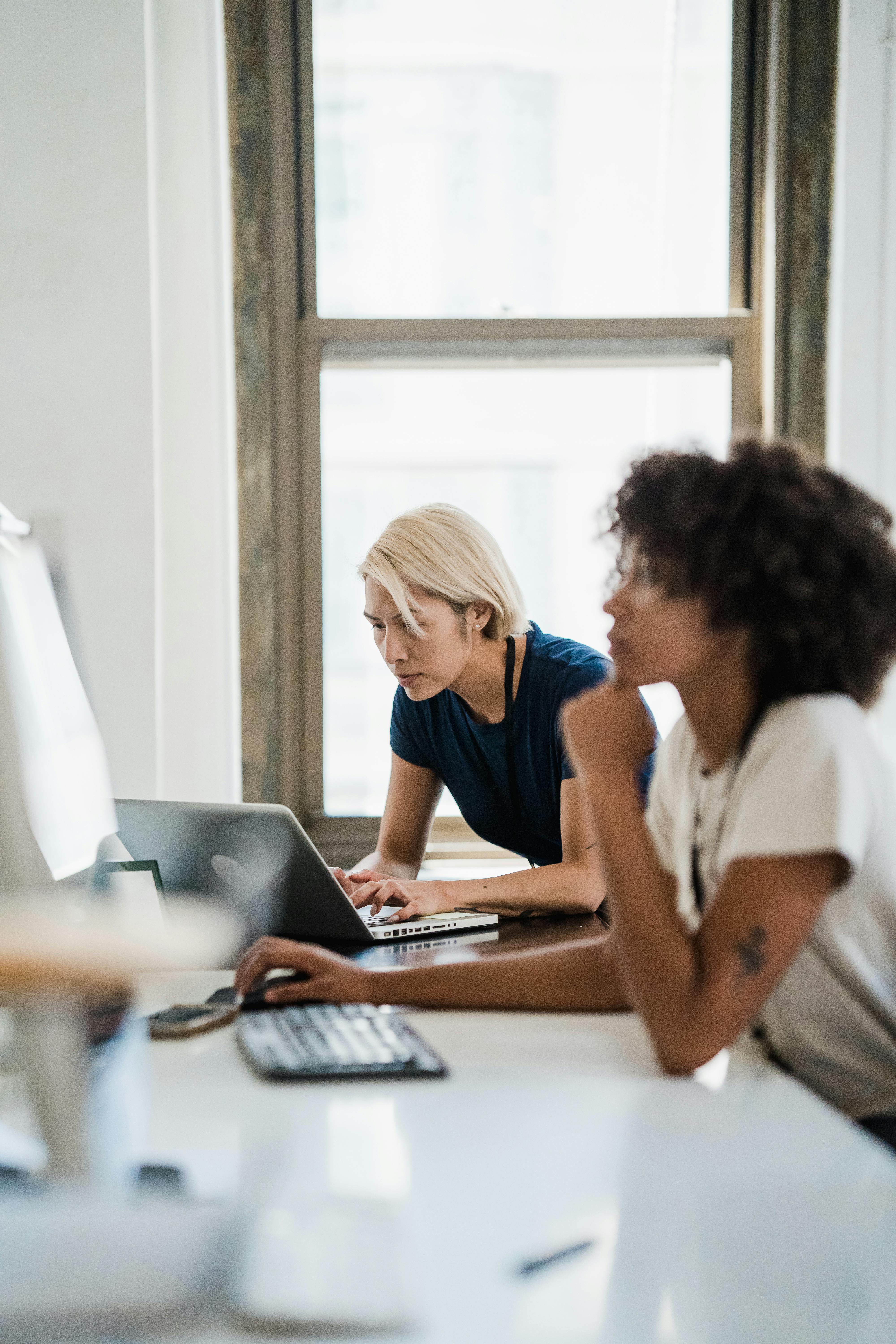 Two women at work focused on their computers