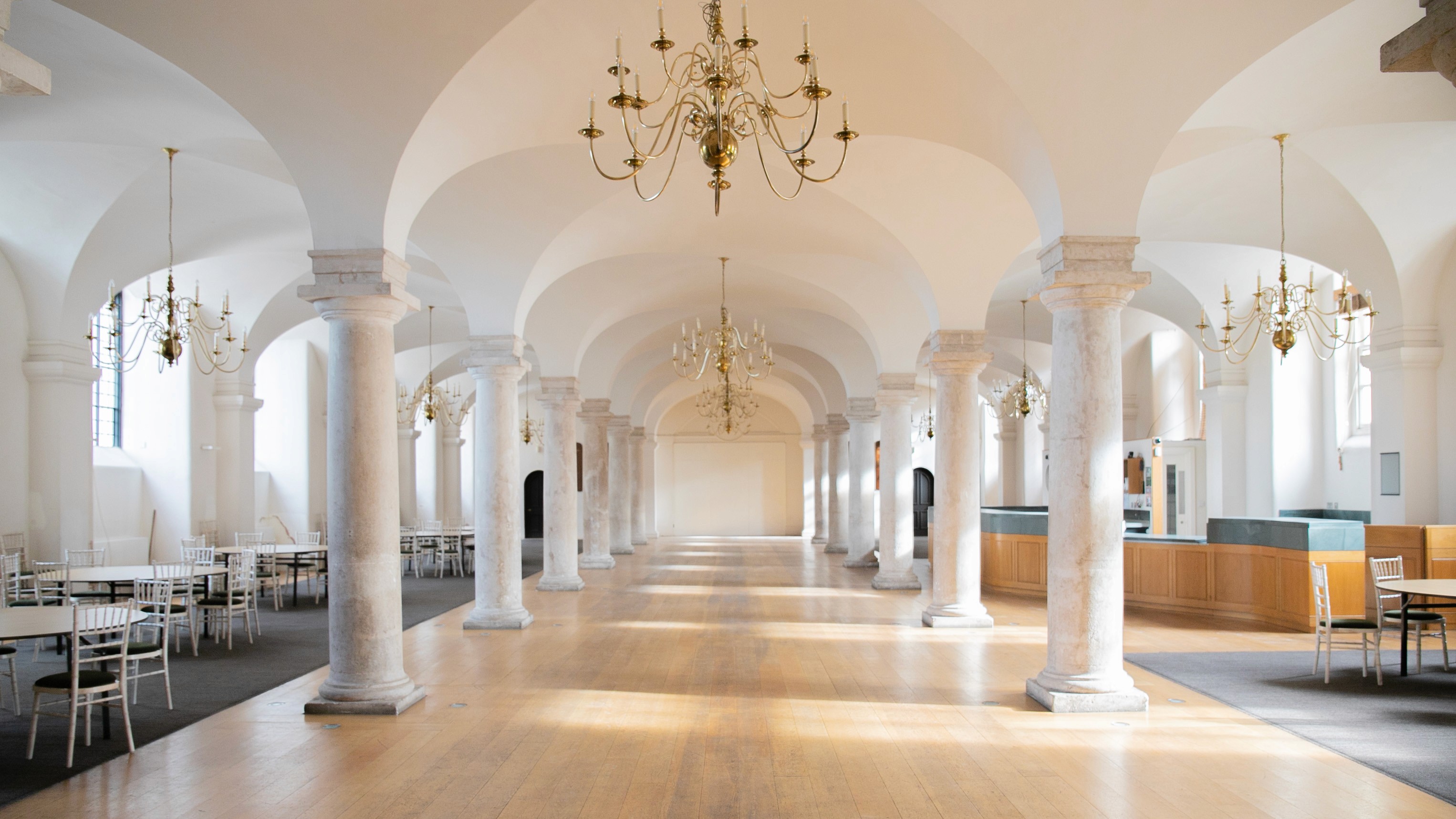 Two classic volkswagen beetles, one green, one cream.