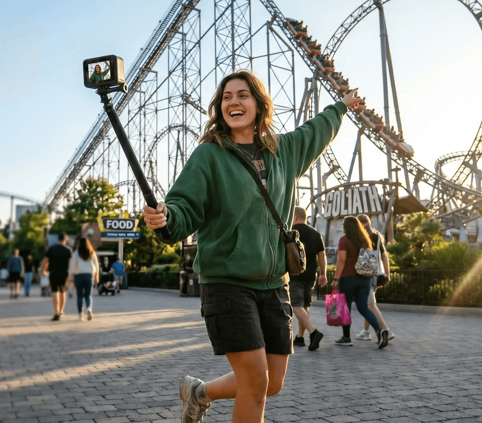 Eine Frau filmt sich selbst mit einem Handy auf einem Selfie-Stick vor einer Achterbahn