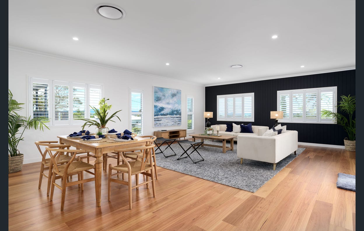 people walking on the beach in front of a city