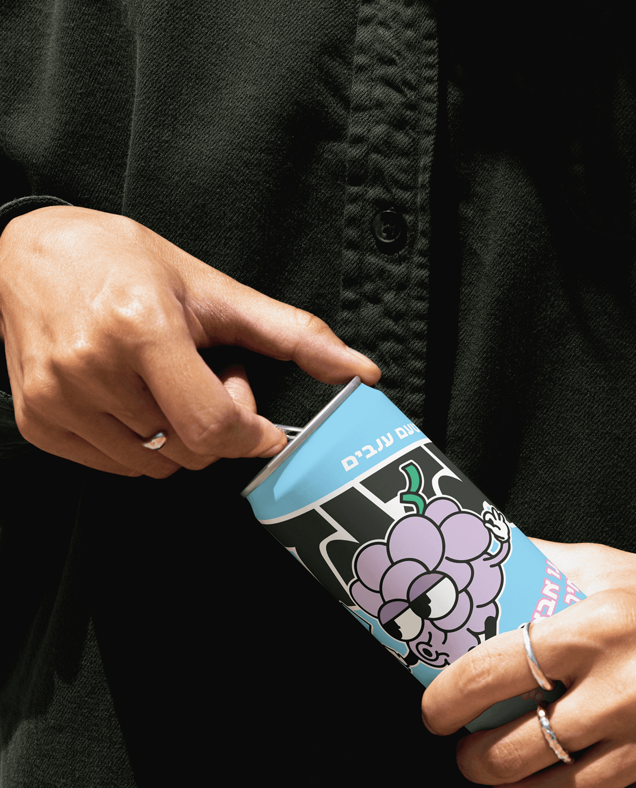 A close-up of a hand wearing multiple decorative rings against a blue background.