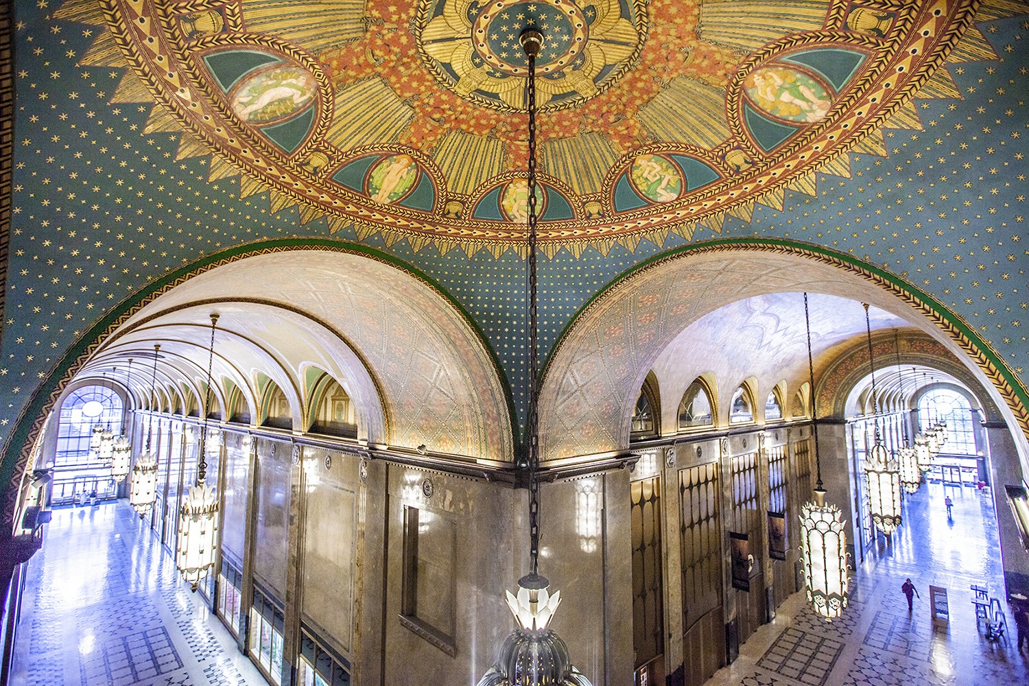 A beautifully decorated ceiling with ornate designs and arches in a lightly lit interior space.