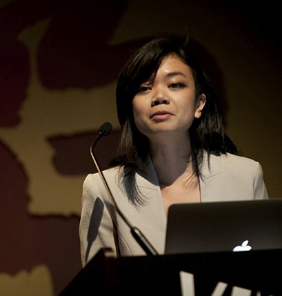 portrait of a woman with a white coat giving a speech