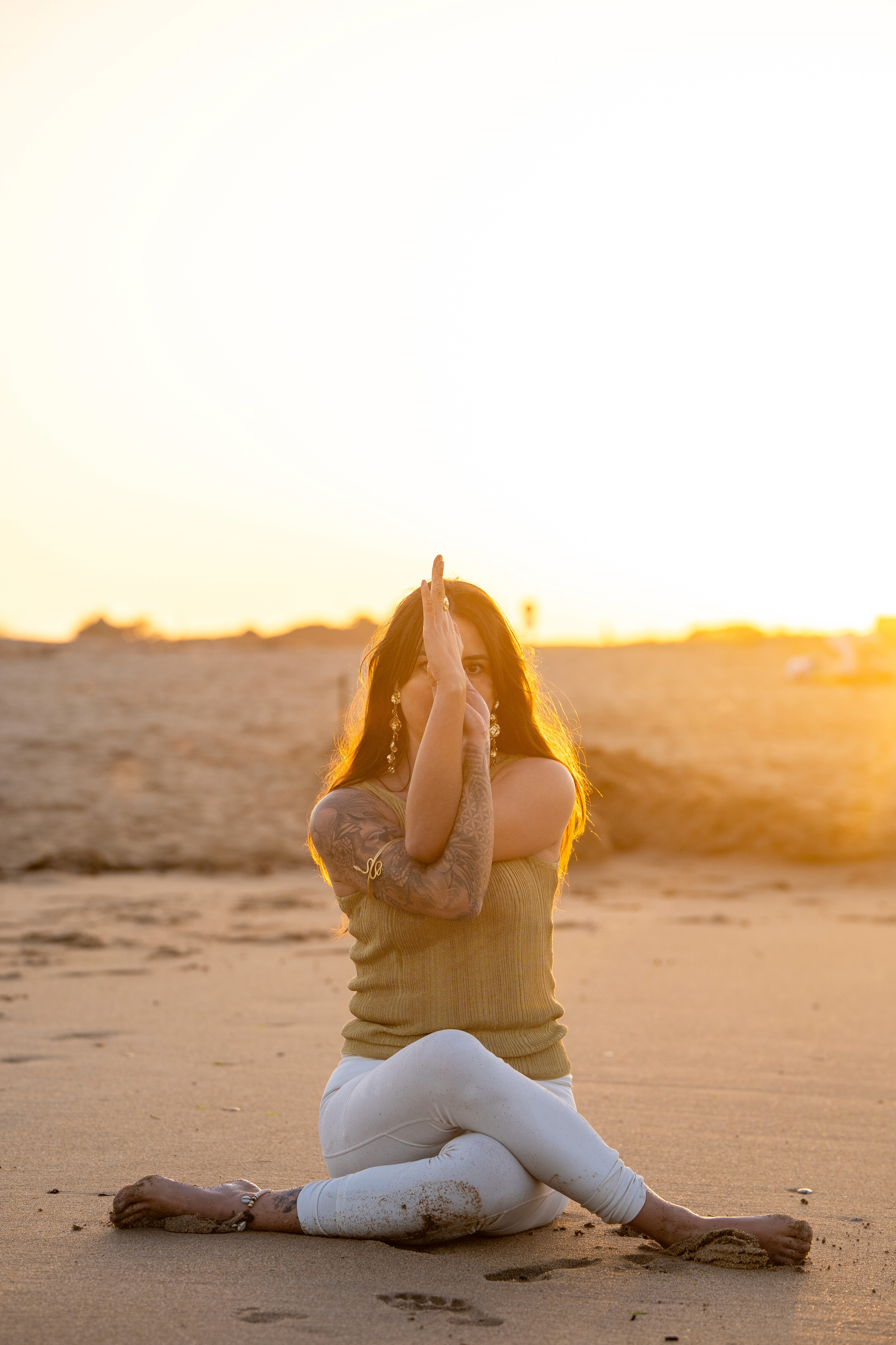 Posture de yoga méditation sur la plage au coucher de soleil, mains jointes en anjali mudra