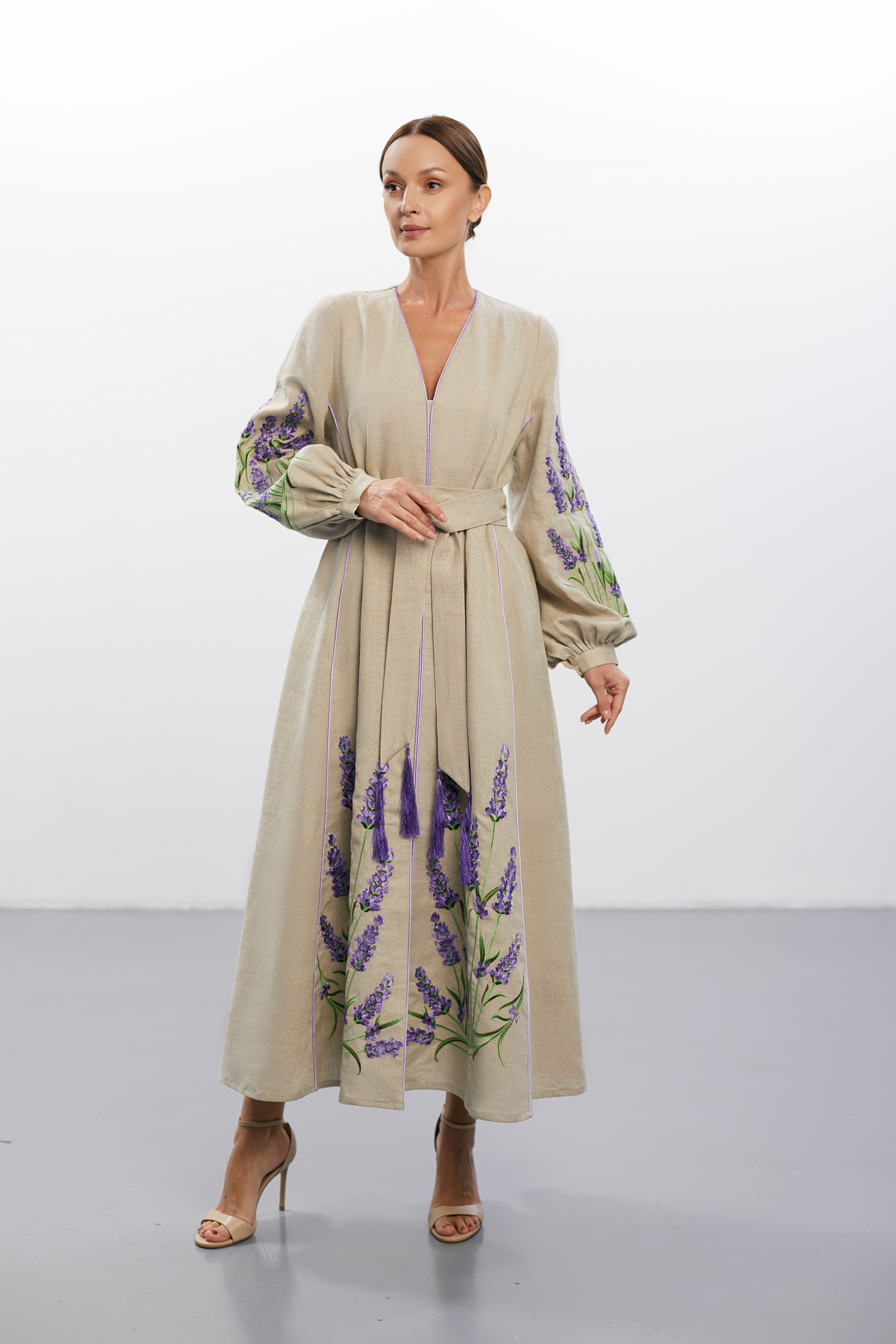 Model wearing ornate vintage-inspired rings, hands raised to frame her face against a soft tonal backdrop