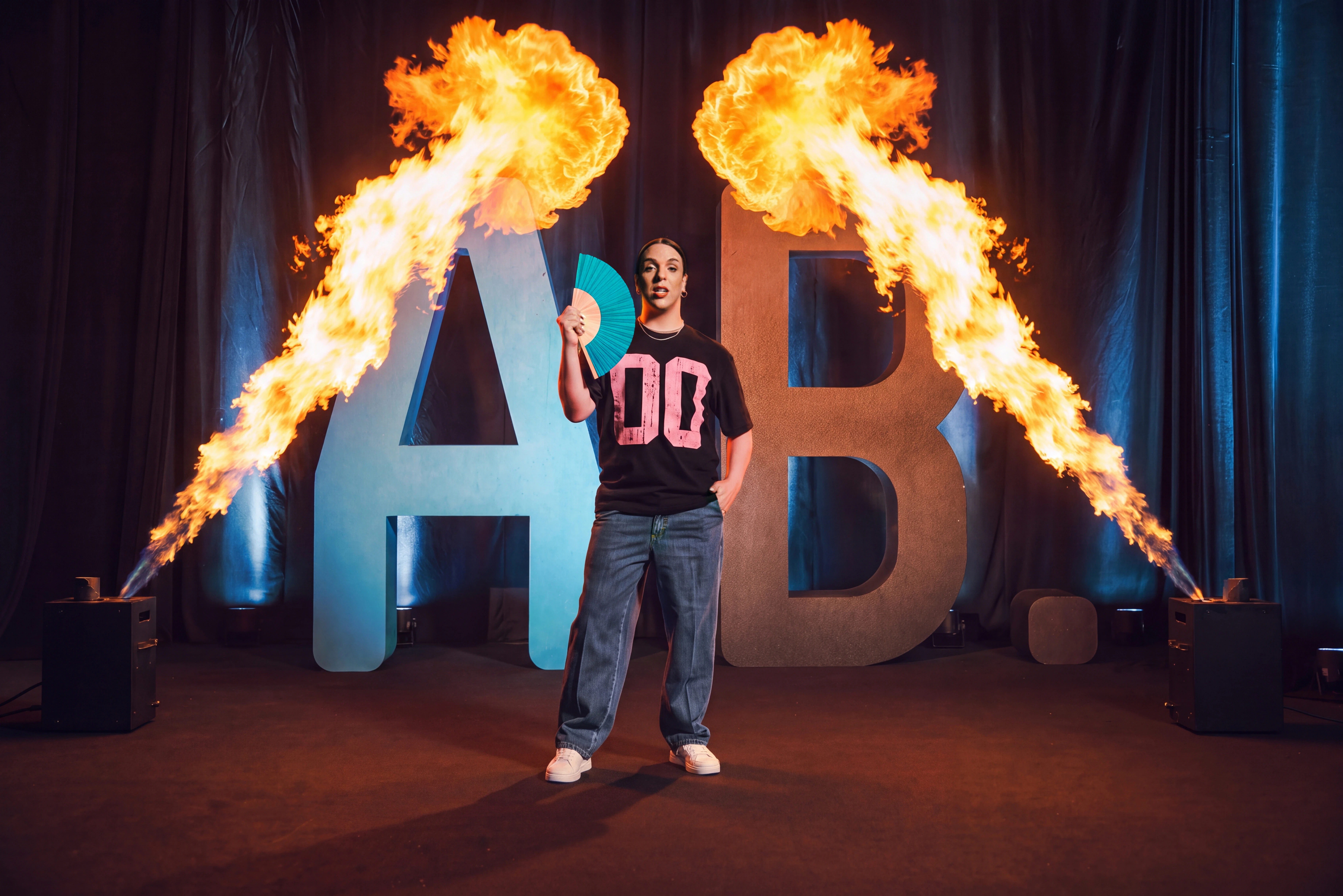 Kiko is Hot on stage between giant AB letters and two flame jets, ActivoBank campaign