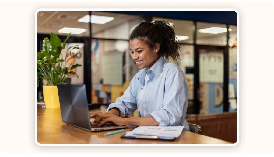 Smiling woman analyzing data on her laptop