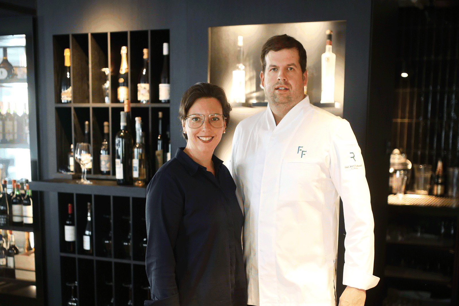 Portrait of the head chef standing at the restaurant entrance.