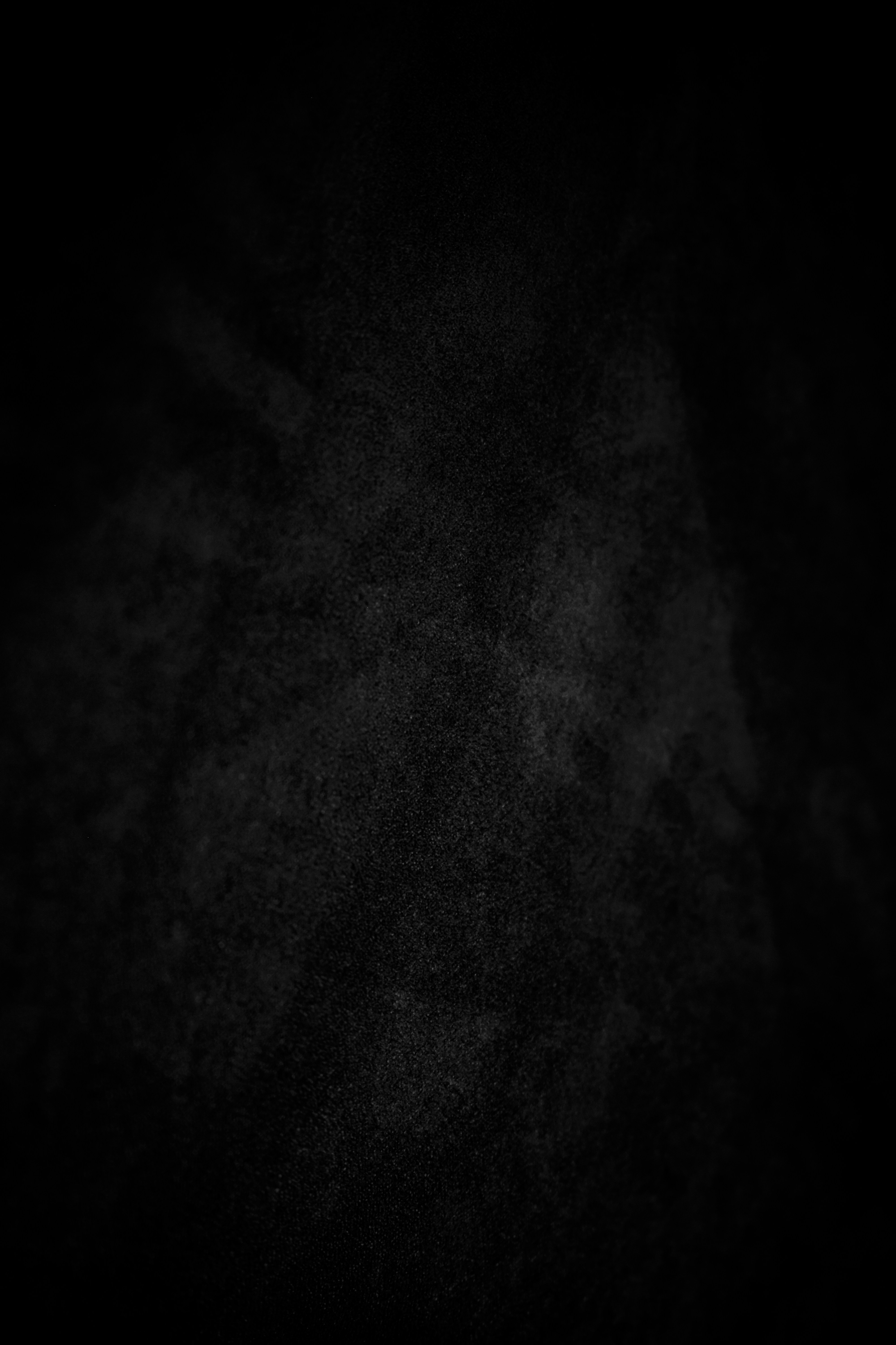 A dark, textured background with subtle white speckles.