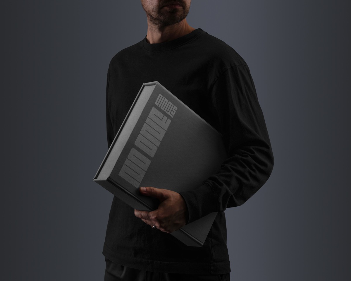 Stilistische Fotografie eines Mannes mit einem Buch mit der Aufschrift NO ONE STUDIO.