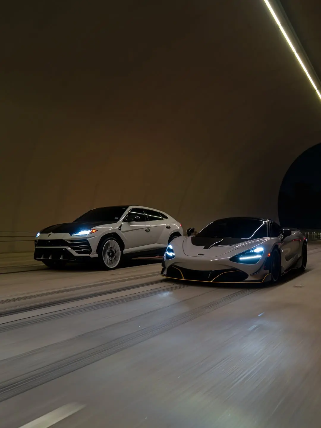 Rolling shot of a ceramic coated McLaren 720S and Lamborghini Urus driving through a tunnel in Houston.
