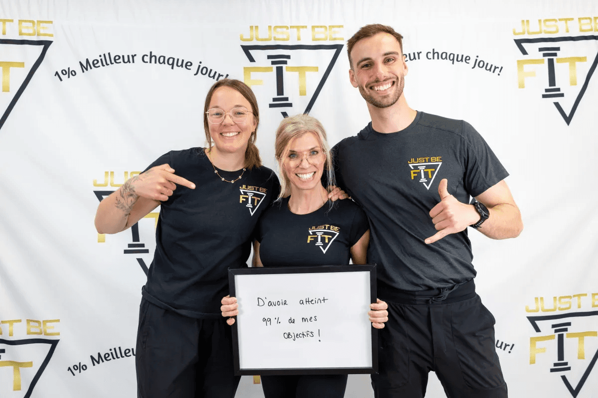 Une femme rayonnante célébrant l'atteinte de 99% de ses objectifs de santé avec l'équipe Just Be Fit.