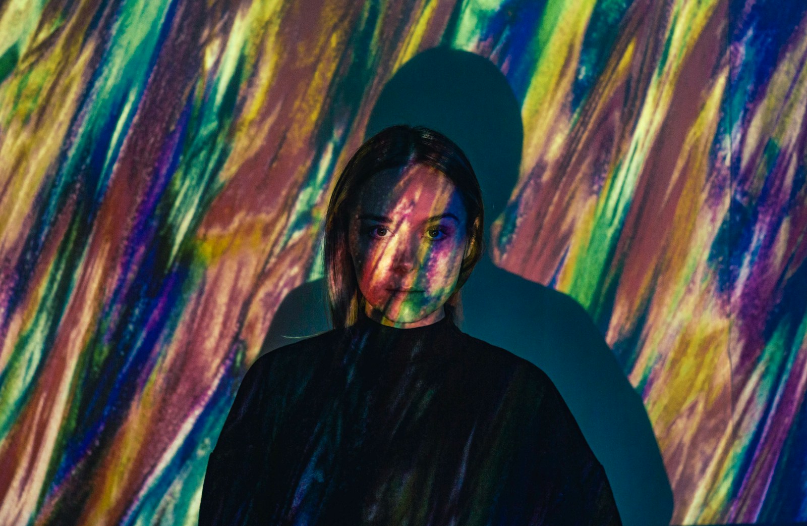 Person illuminated by colorful projected light, representing human-centered, future-ready web experiences