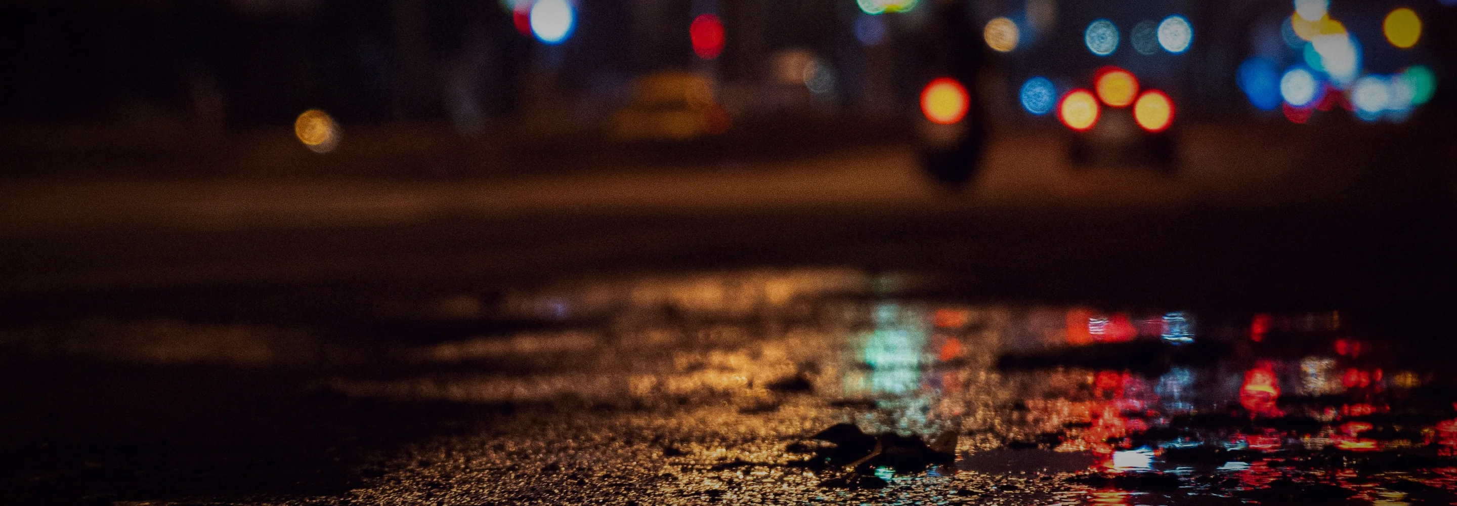 Neon reflected in a puddle on a wet street