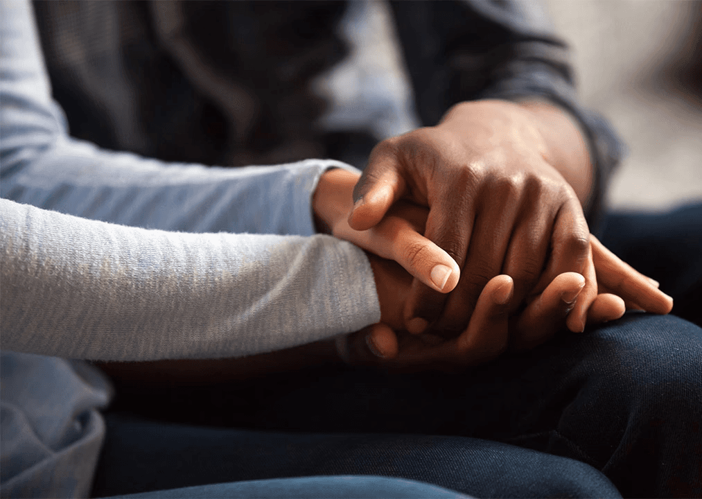 Hands clasped together in a moment of grief and support, representing families coping with wrongful death.