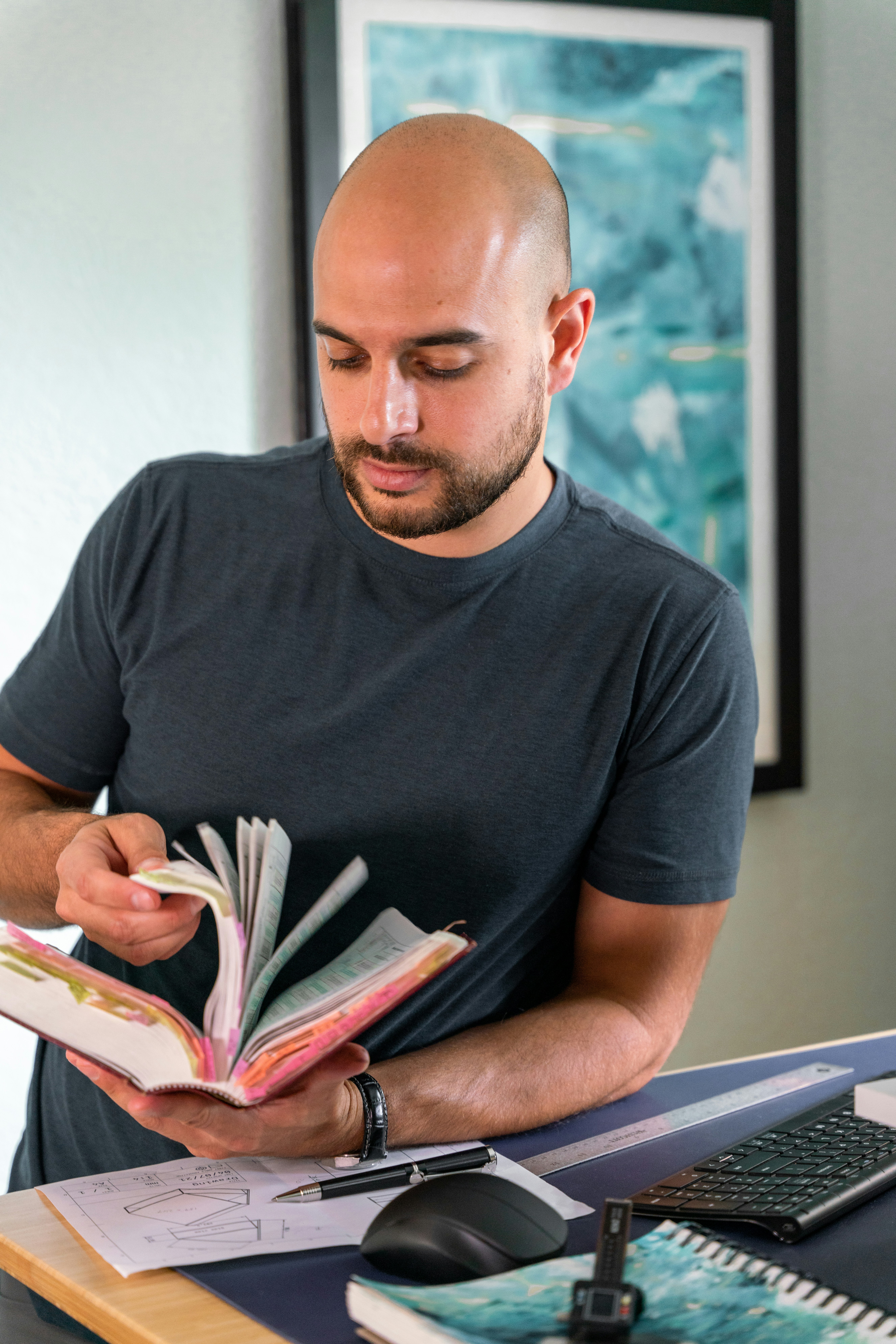 a man sitting at a desk reading a book