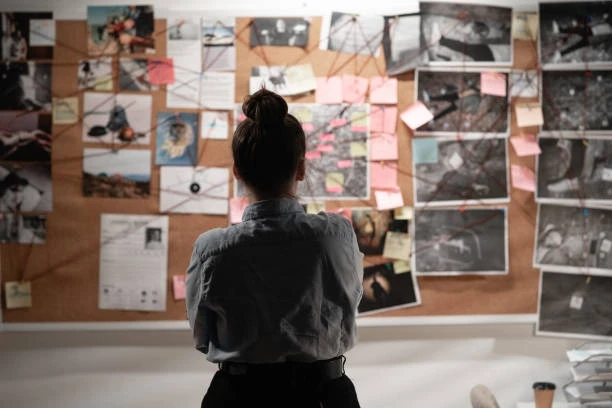 woman looking on the board with clues