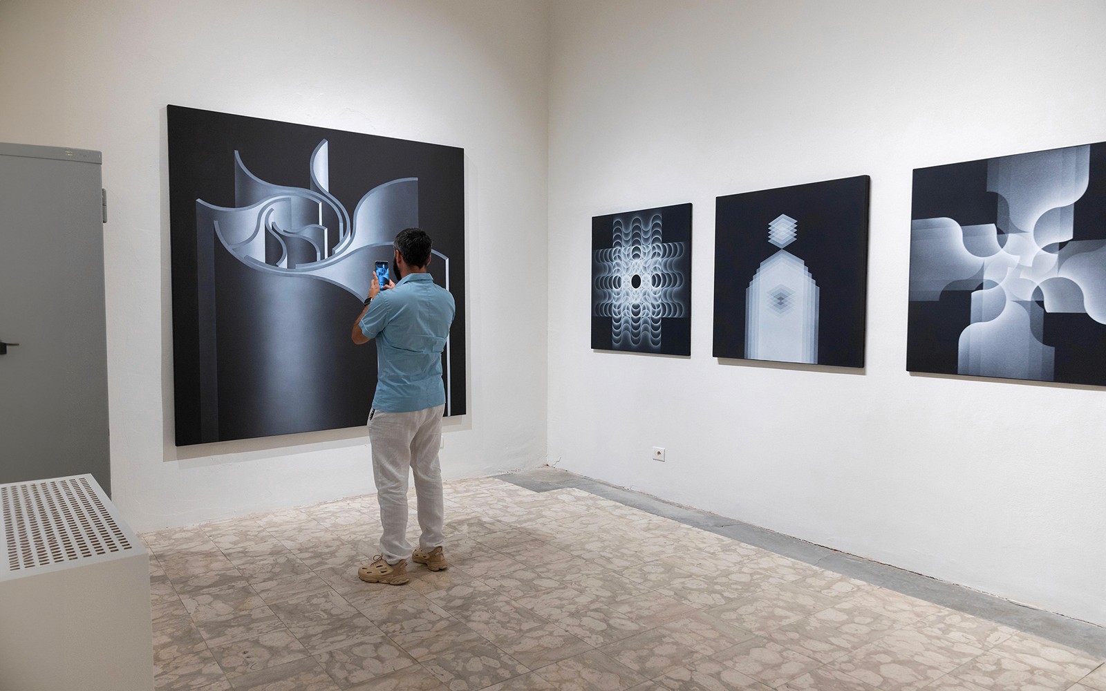 Visitor photographing abstract art at Palazzo delle Papesse exhibition in Siena.