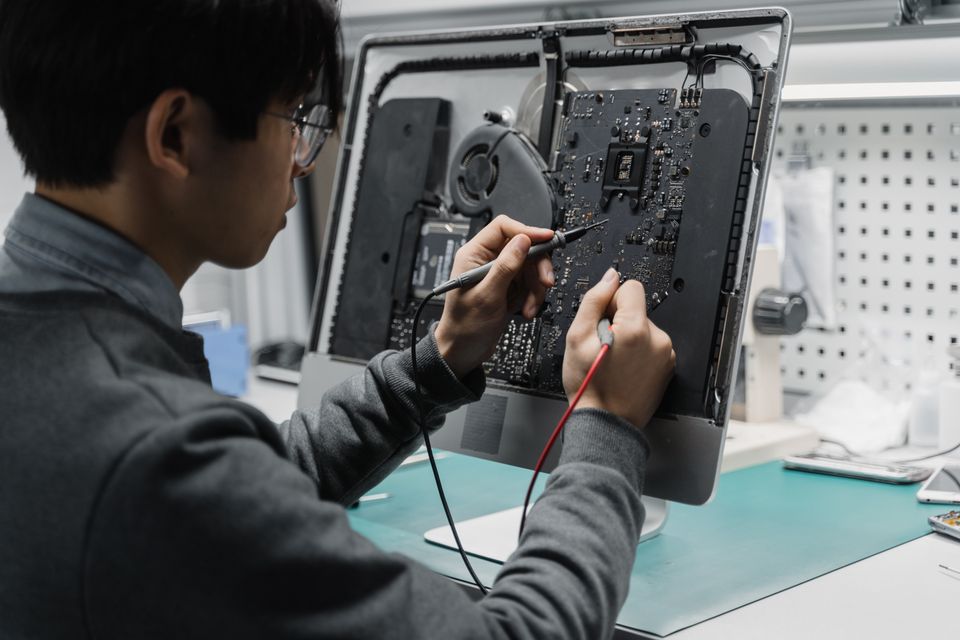 Un technicien vérifie les composants d’un ordinateur dans son atelier.