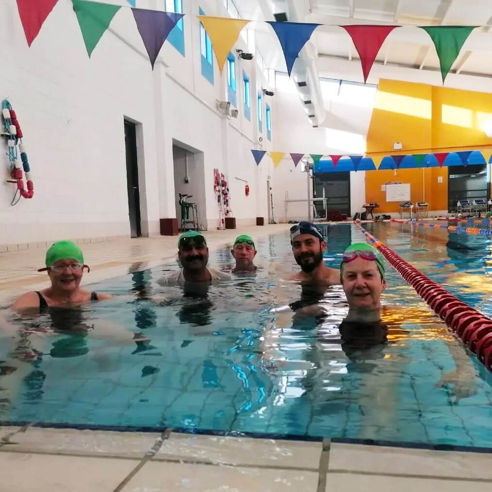 Members swim class in the pool