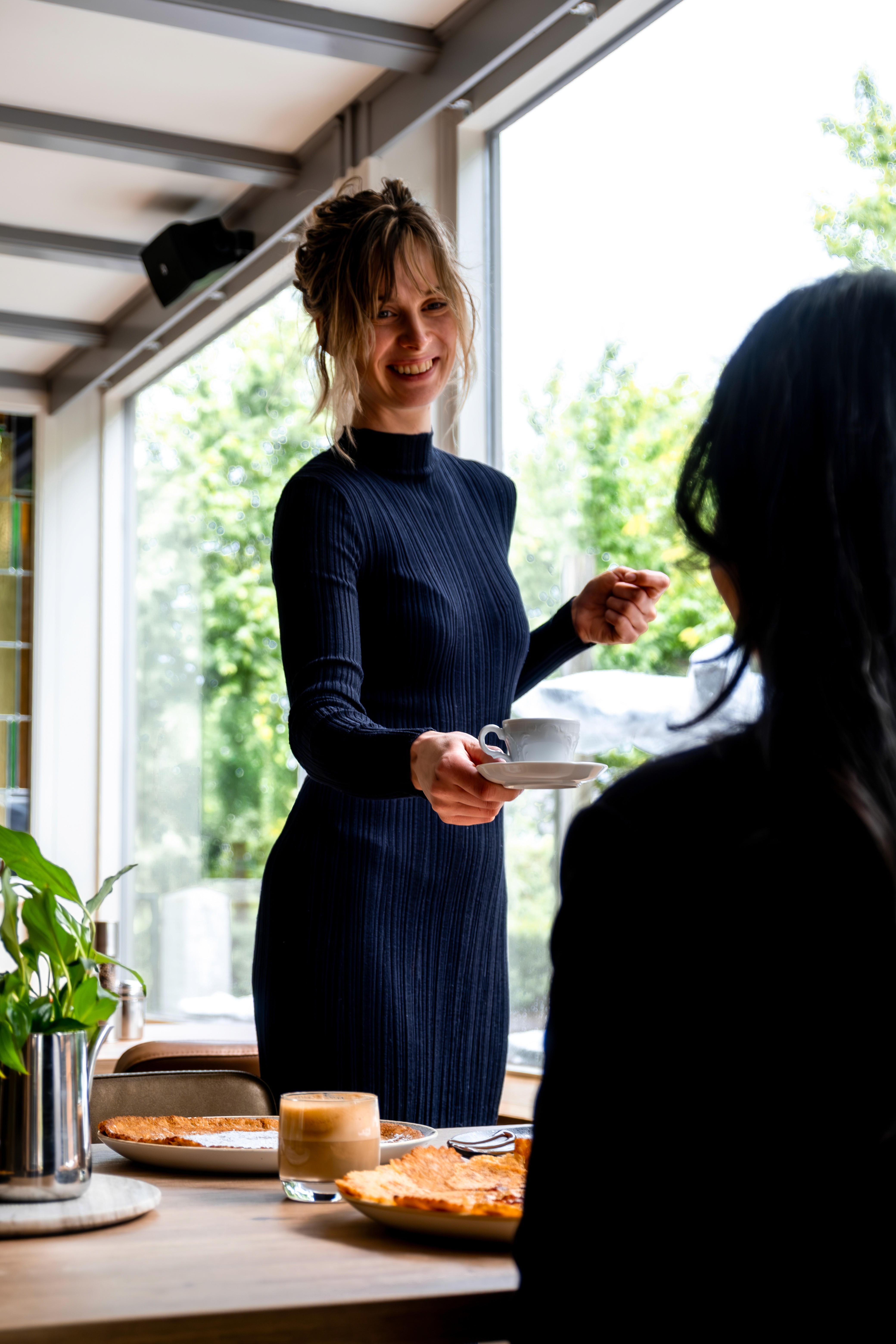 Medewerker serveert koffie aan gast bij Pan & Cook in Prinsenbeek.