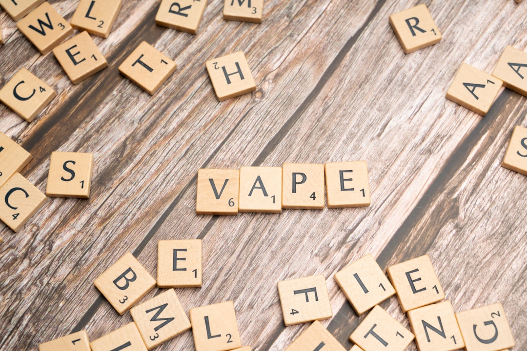 scrabble tiles spelling the word vape on a wooden surface