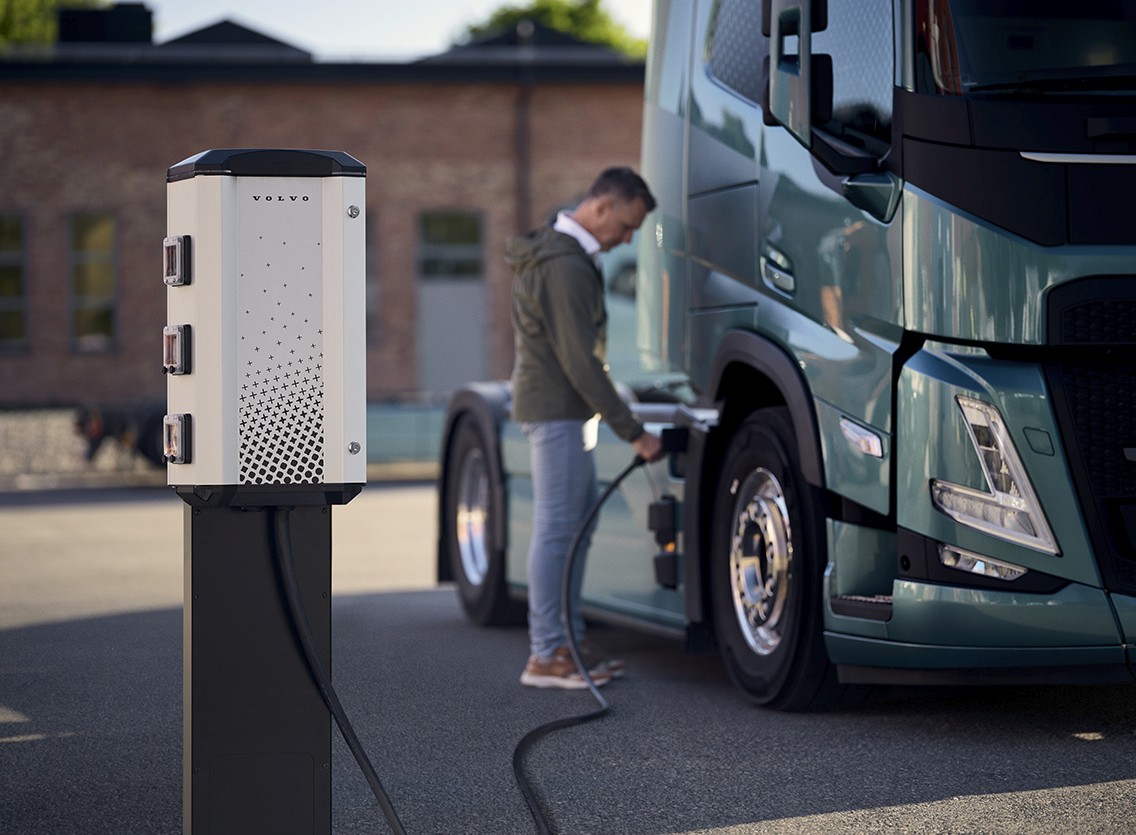 Electric truck charging at a station in a European city, showcasing the infrastructure needs for EU emission compliance.