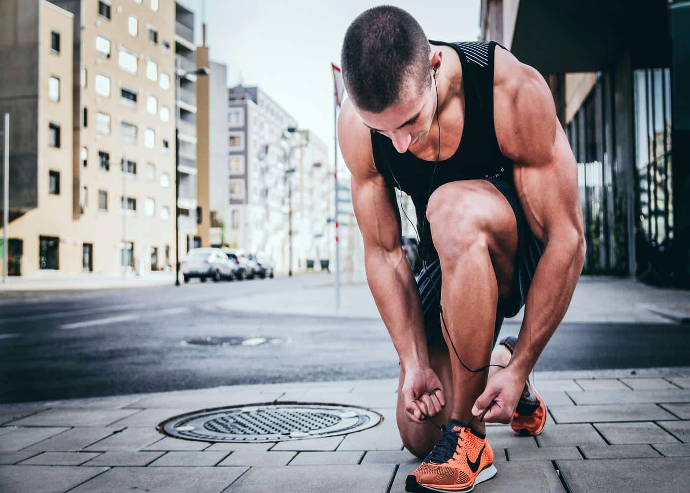 Why is fitness so important? Man kneeling down and tying his shoe laces