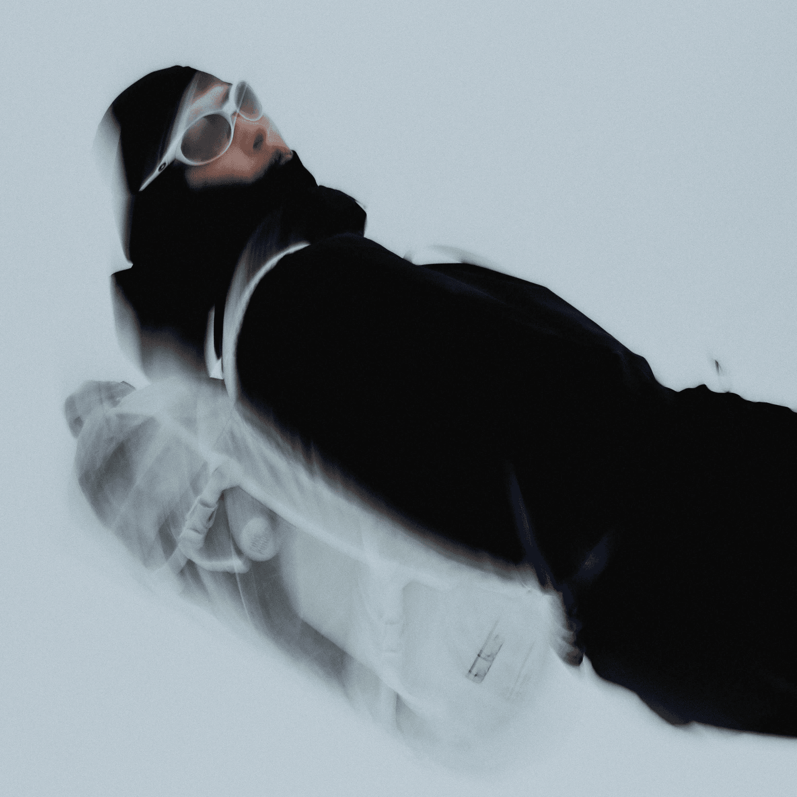 blurry photo of a woman in black outfit with white backpack.