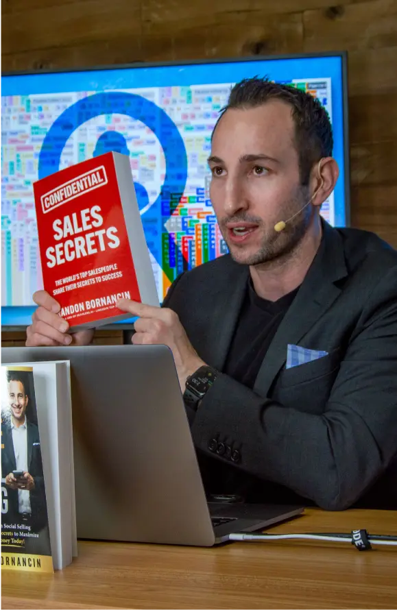 Brandon holding his sales secrets book