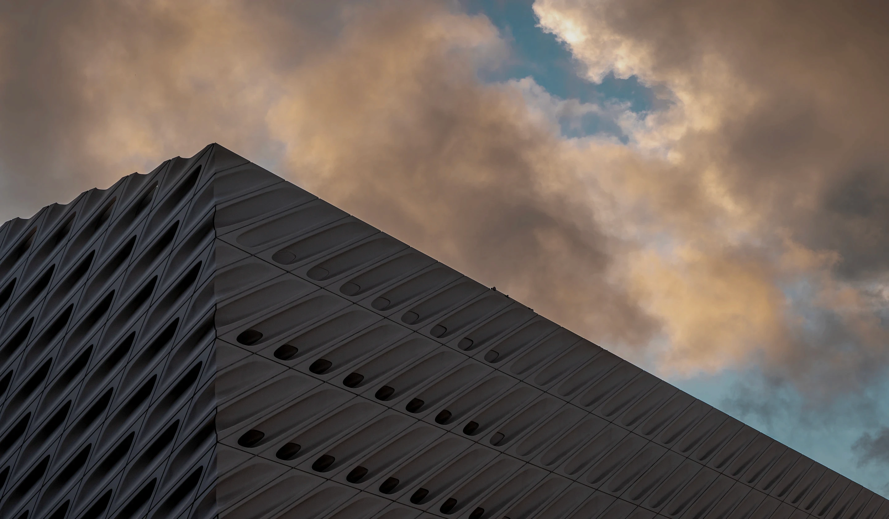 Angular concrete building silhouetted against a dusk sky